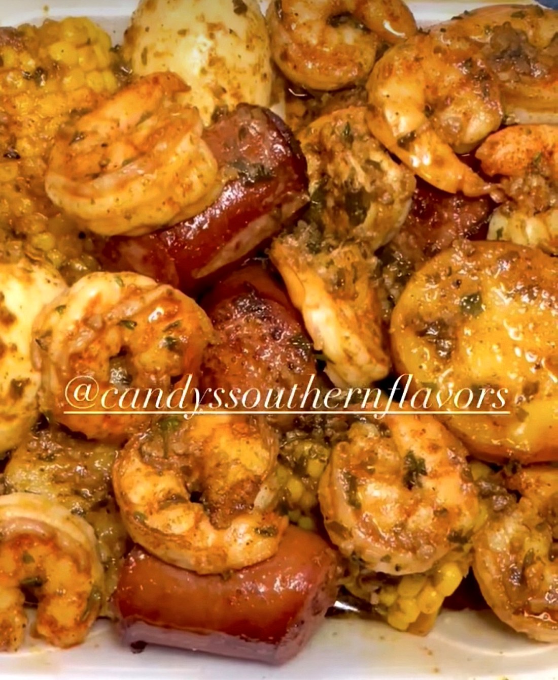 Close-up of a seafood boil with shrimp, sausage, corn and eggs